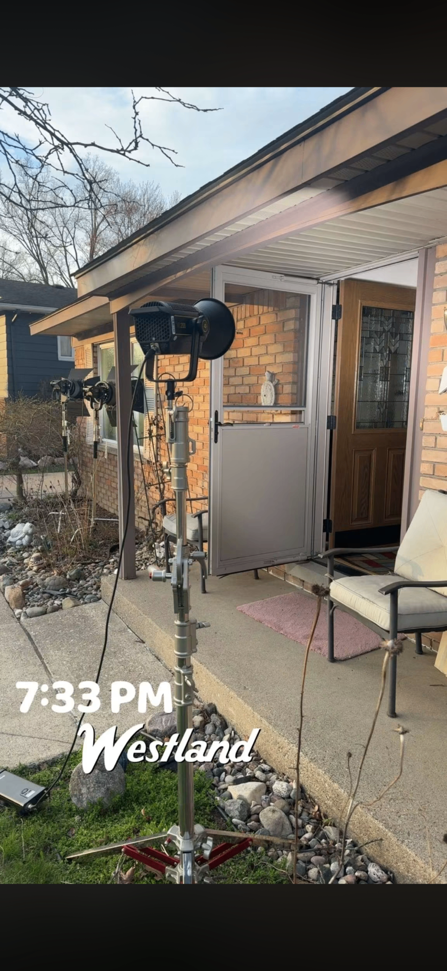 Lighting stands set up outside a house at golden hour in Westland, Michigan