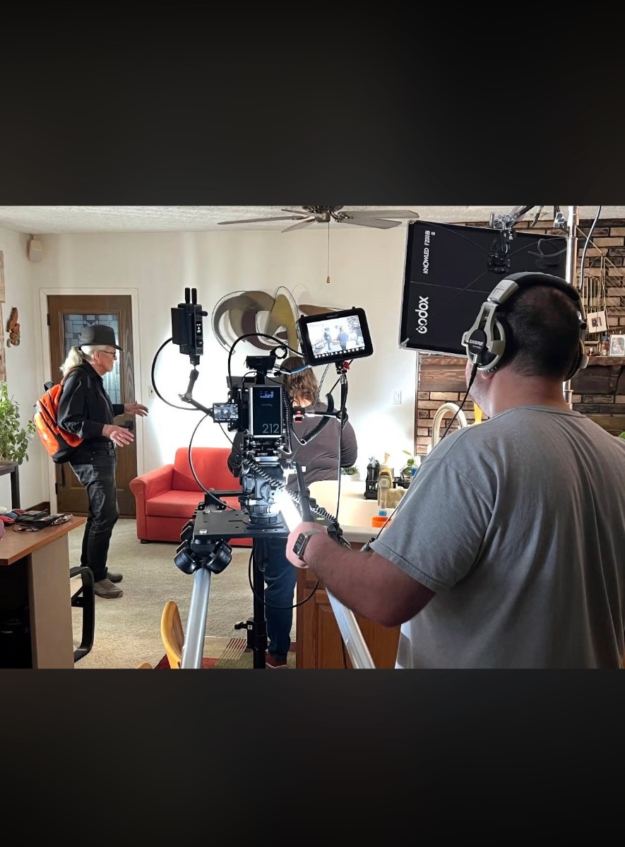 Crew filming an interview in a living room with monitor and softbox lighting